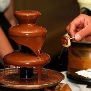 Chocolate flowing from a two-tier fountain setup.