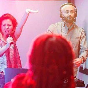 Group of people singing karaoke and having fun at a party.