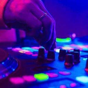 lose-up of DJ hands mixing tracks with neon lighting.