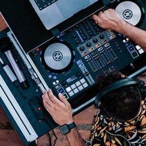 DJ using turntables and mixing console at a live event.