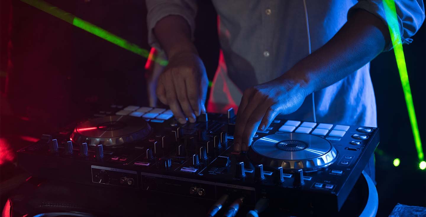 DJ adjusting sound and lighting controls during a performance