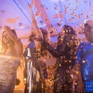 Women celebrating at a party with confetti falling around them