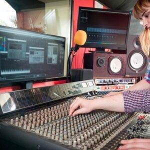 Sound engineer adjusting audio levels on a professional mixing desk