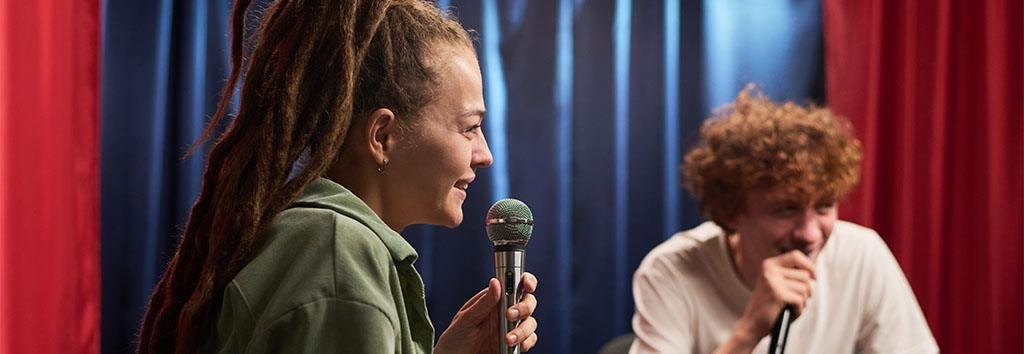 Young woman speaking into a microphone during an indoor session