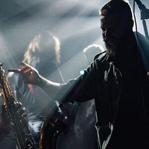 Saxophone musician performing live on stage with dramatic lighting