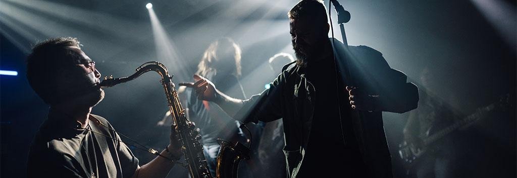 Saxophone musician performing live on stage with dramatic lighting