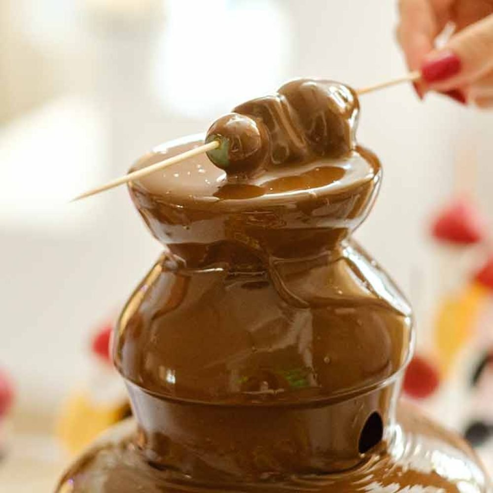 Chocolate fountain with strawberries on skewers